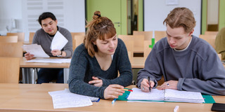Studierende im Seminarraum sitzen zusammen und arbeiten